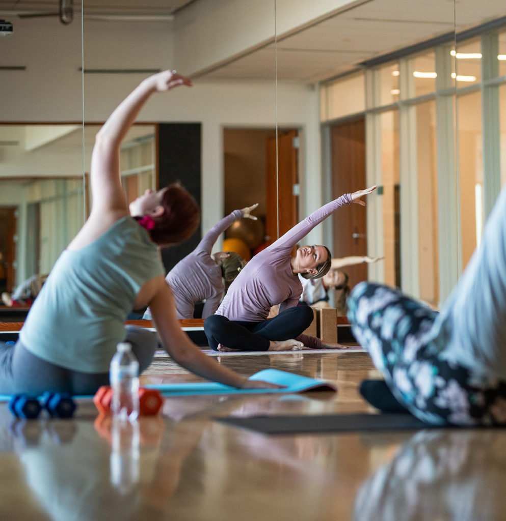 Students during a yoga session inside the nursing and health sciences building.
