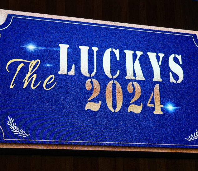 Sign welcoming guests to The Luckys 2024. Sign reads "The Luckys 2024" with blue background and white and gold lettering.