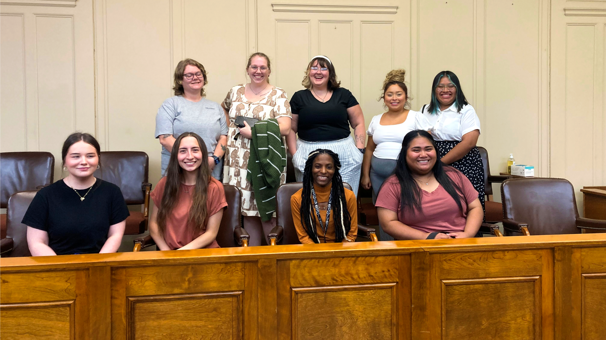 Nine A&M-Commerce students sit in two rows within the jury box of a courtroom.