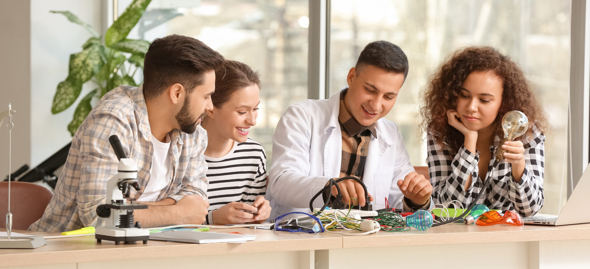 A group of students experimenting with light bulbs and switches. 