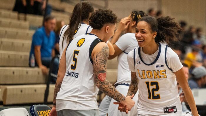 Two basketball players smile at each other and celebrate success.