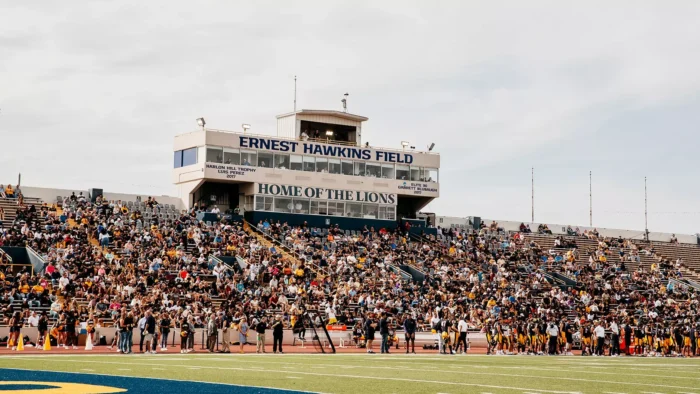 Football stadium bleachers are filled with fans.