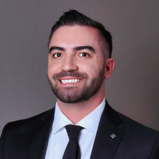 A headshot photo of a person in a suit.