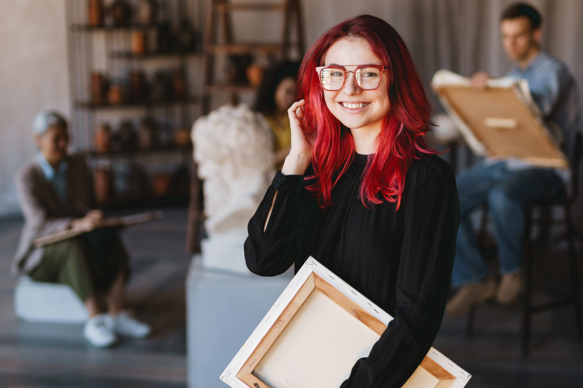 Young student woman smiling at camera during class in art school indoors