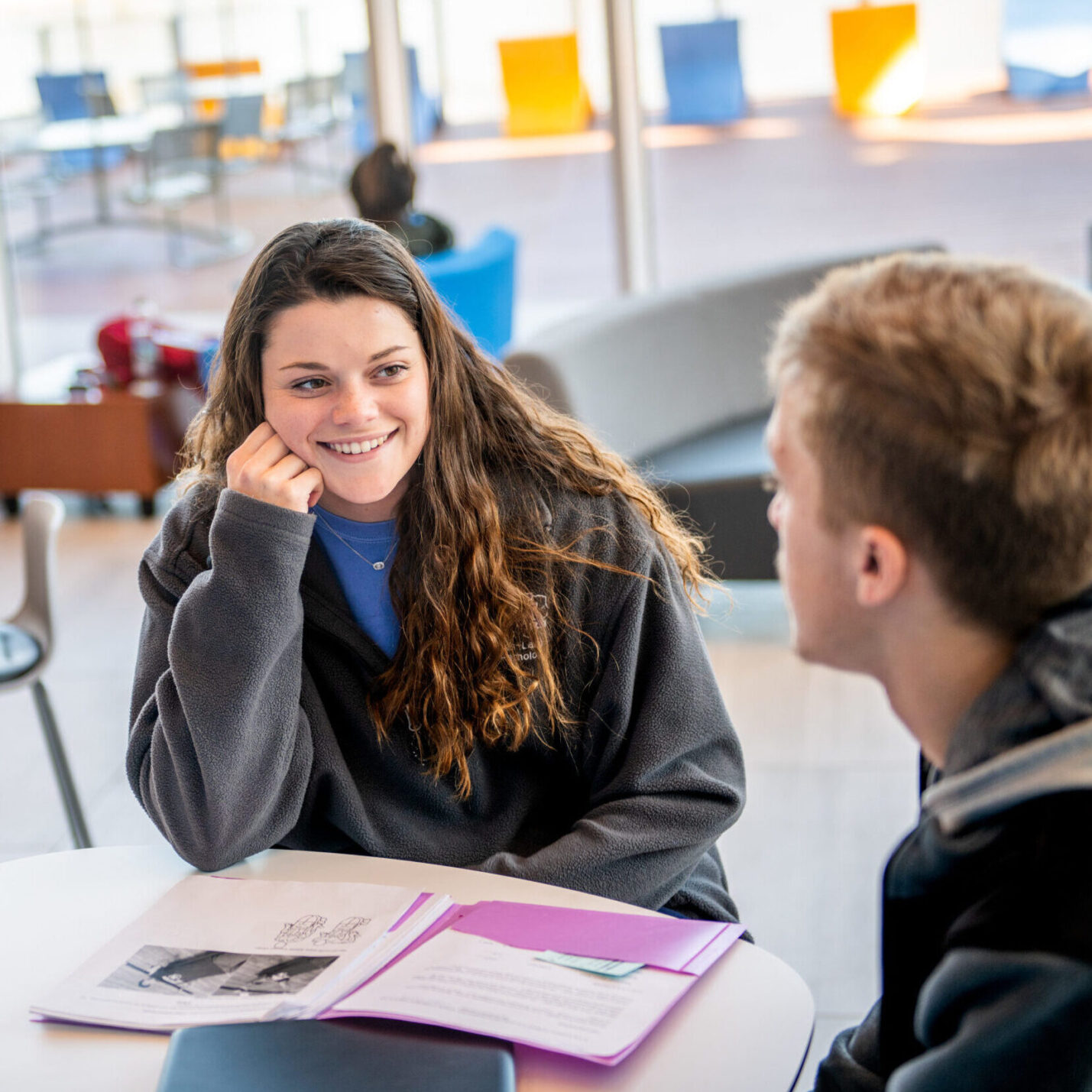 Young woman speaking with man in classroom environment