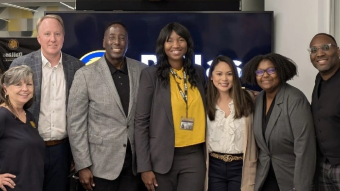 A group of people in business attire standing shoulder to shoulder for a photo.