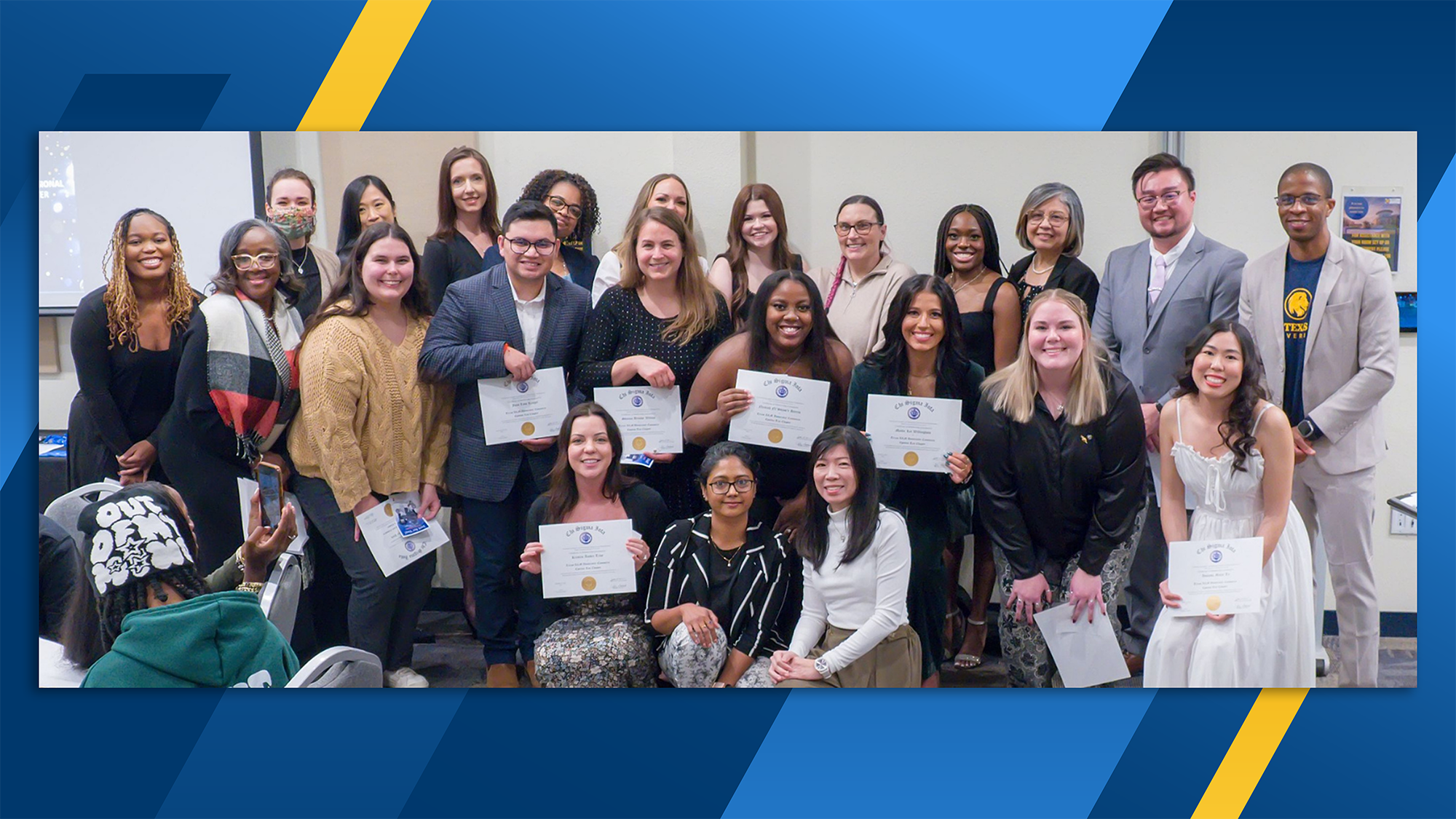 Three rows of people including counseling students and faculty pose with membership certificates.