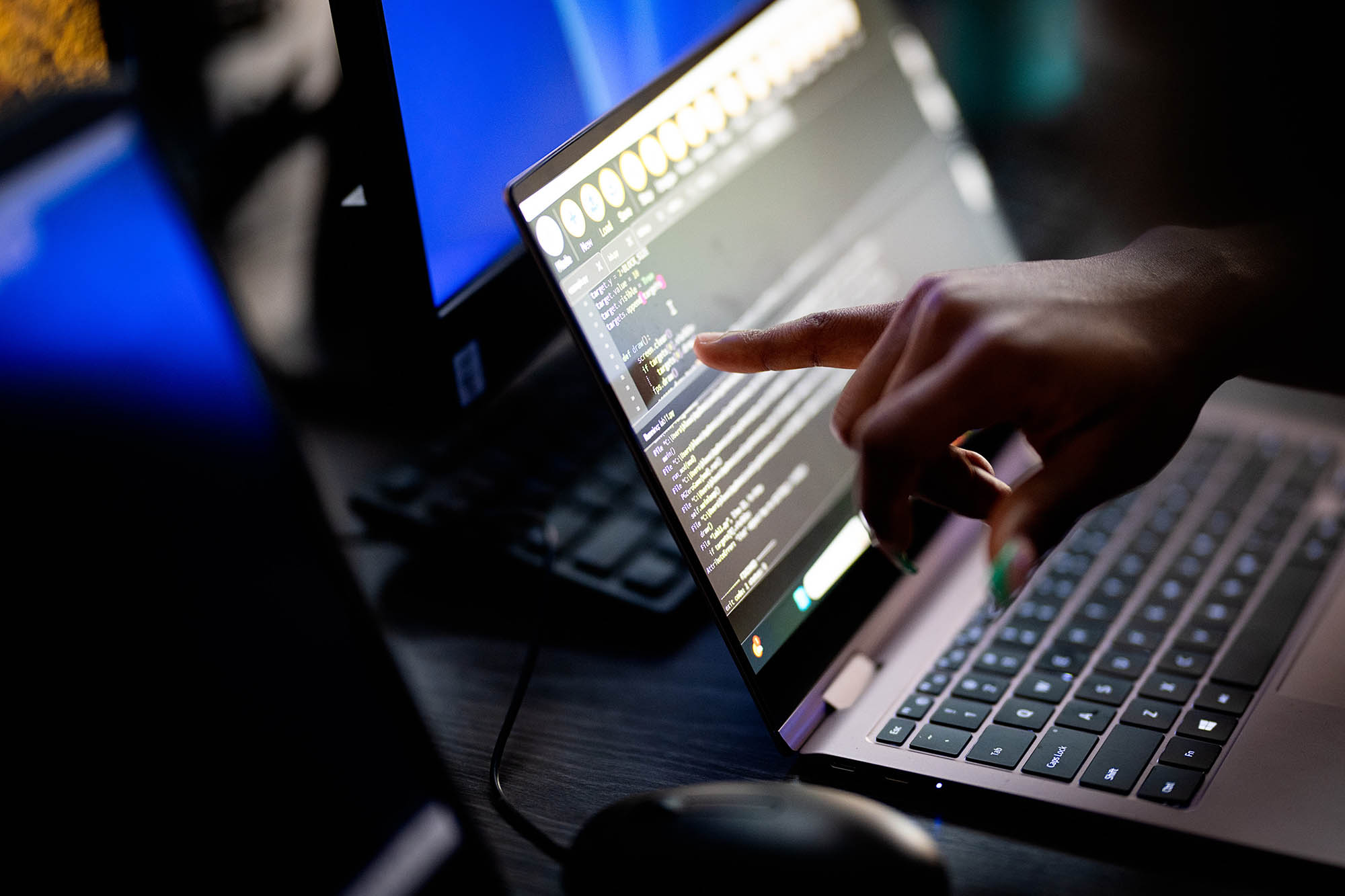 Close-up of a student coding on a laptop during a collaborative computer science class at East Texas A&M University.